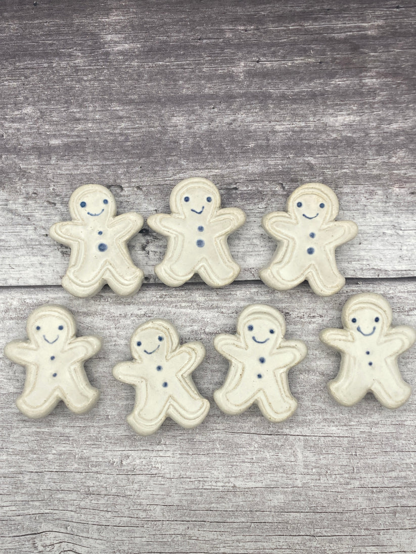 Gingerbread men cookies with smiling faces on a wooden surface