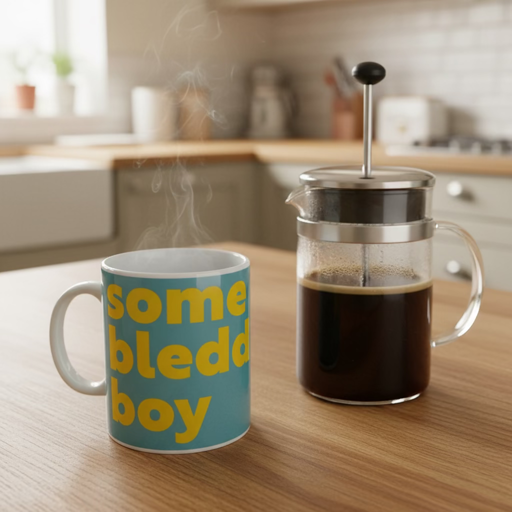 Blue cup with yellow text 'some bleded boy' on a wooden surface