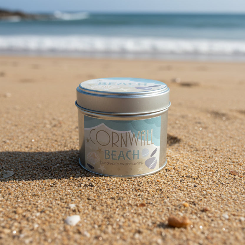 Candle labelled Cornwall Beach on a sandy beach